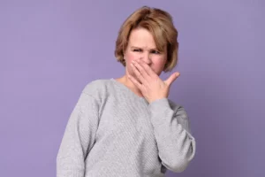 Femme se bouchant le nez face à des odeurs de putréfaction